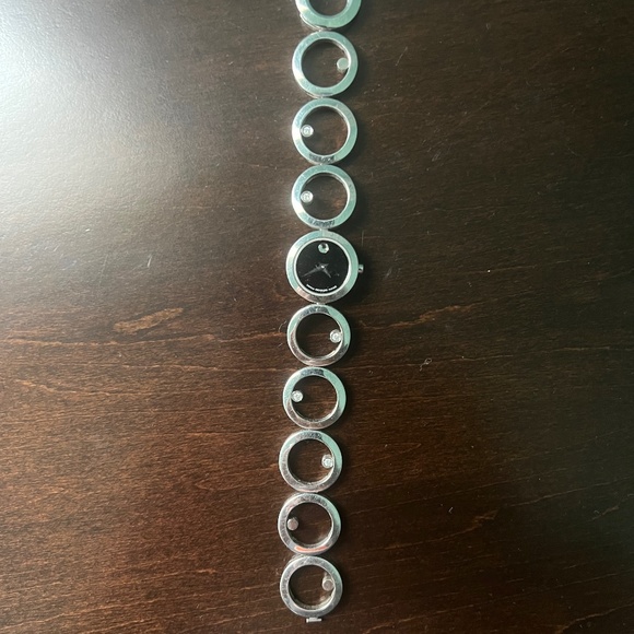 Silver Movado watch with six diamonds.